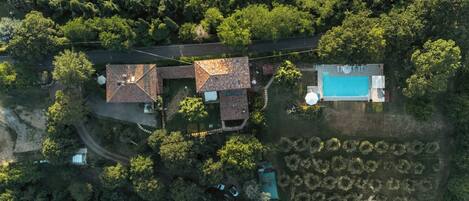 Vista aérea de un barrio residencial con varias casas, una piscina y un jardín.