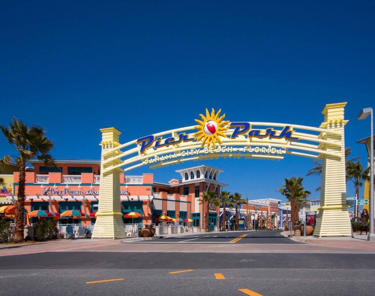 Ein großes Schild mit den Aufschriften "PIER PAKK" und "Panama City Beach, Florida", das einen Ort kennzeichnet.