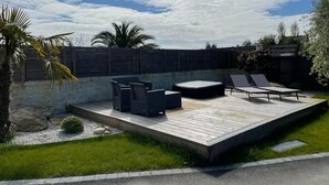 Una terraza al aire libre con asientos y una pared de piedra.