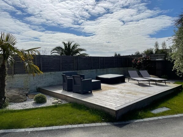 Eine Terrass mit Sitzgelegenheiten und einer Steinmauer.