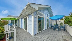 A house with a covered deck, sliding glass doors, and outdoor furniture. - Bethany Beach * 4BR Luxury House (Bethany Beach)