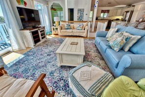 A living room with a TV, sofa, coffee table, and a patterned rug. - Bethany Beach * 4BR Luxury House (Bethany Beach)