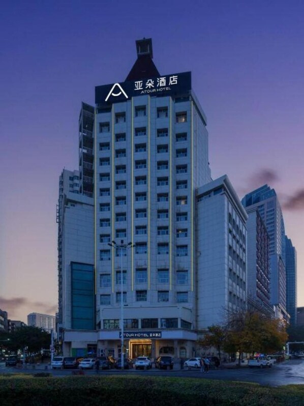 Un hotel de varios pisos con un llamativo logotipo con forma de A en la parte superior.