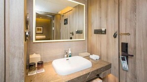 A modern bathroom with a large mirror, a white sink, and a wooden vanity. - Atour Hotel (Ürümqi)