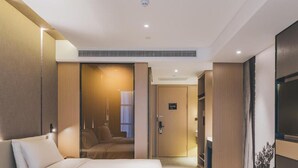 Una habitación de hotel moderna con una cama grande, un escritorio y un armario.