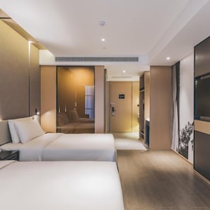 Habitació d'hotel moderna amb un llit gran, un escriptori i un armari.