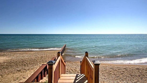 A wooden boardwalk leading to a beach with clear blue water. - Fort Gratiot Lake House on Lake Huron w/ Patio & Deck! (Fort Gratiot Township)