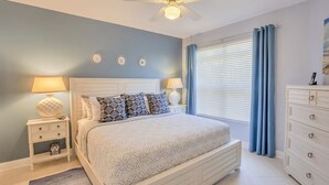 A bedroom with a bed, nightstands, a dresser, a ceiling fan, and a window with curtains. - Few days still available this winter! King-size bed. Free parking. Renovated! (Clearwater)