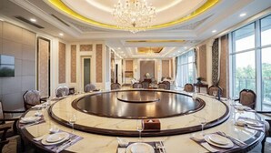 A conference room with a round table, chairs, and a chandelier. - Dongtai Guest House (Dongtai)