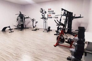 A gym with various exercise equipment, including stationary bikes and weight machines. - Dongtai Guest House (Dongtai)