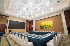 A conference room with a long table, white chairs, and a projector screen. - Dongtai Guest House (Dongtai)
