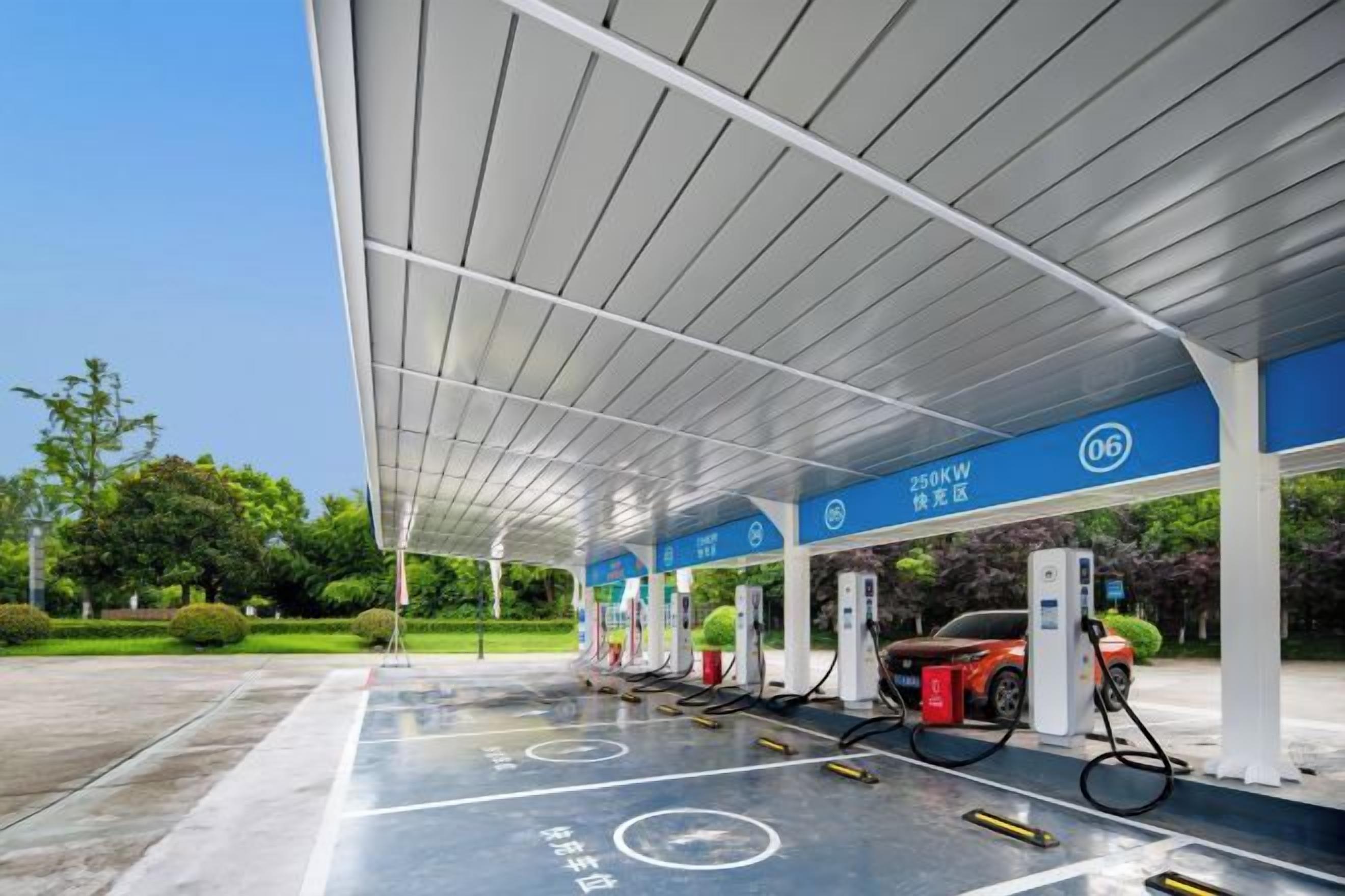 A gas station with multiple fuel pumps, a covered area, and a clear sky.