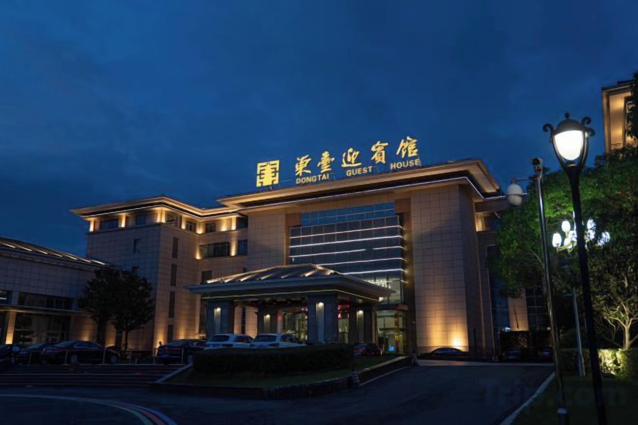 A hotel with a prominent entrance, a covered outdoor area, and a well-lit facade.