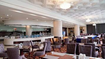A hotel lobby with a bar area, seating arrangements, and a modern ceiling design.