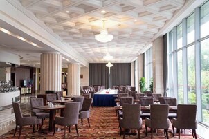 Un comedor de hotel con una mesa larga, varias sillas y una barra.