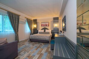 Un dormitorio con cama, mesitas de noche, un escritorio y una silla.