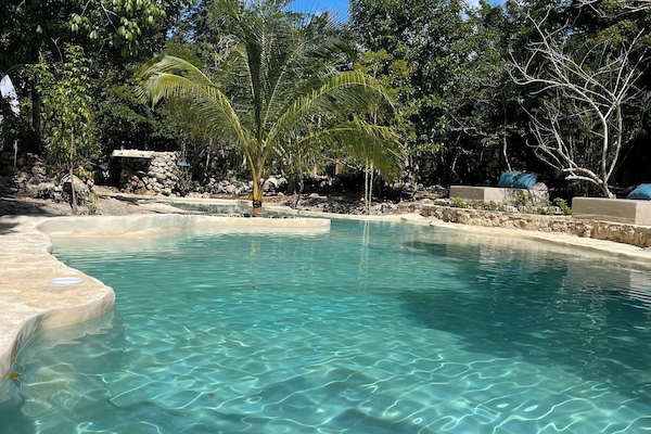 Una piscina al aire libre, sillones reclinables de piscina