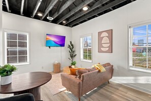 Bright, stylish living space with exposed beam ceilings and a smart TV