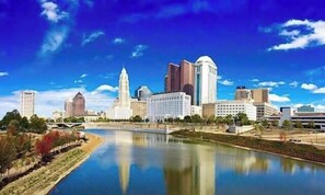 A cityscape with a river, buildings, and a clear sky.