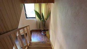 En trätrappa med utsikt över ett fönster och en krukväxt.