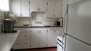 A kitchen with white cabinets, a microwave, a toaster, and a refrigerator. - Entire basement apartment, Prime location! (Salt Lake City)