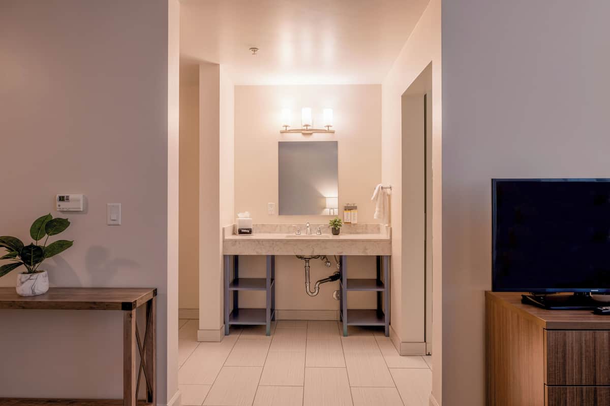 deluxe room, 2 queen beds | bathroom | hair dryer, towels, soap, shampoo
