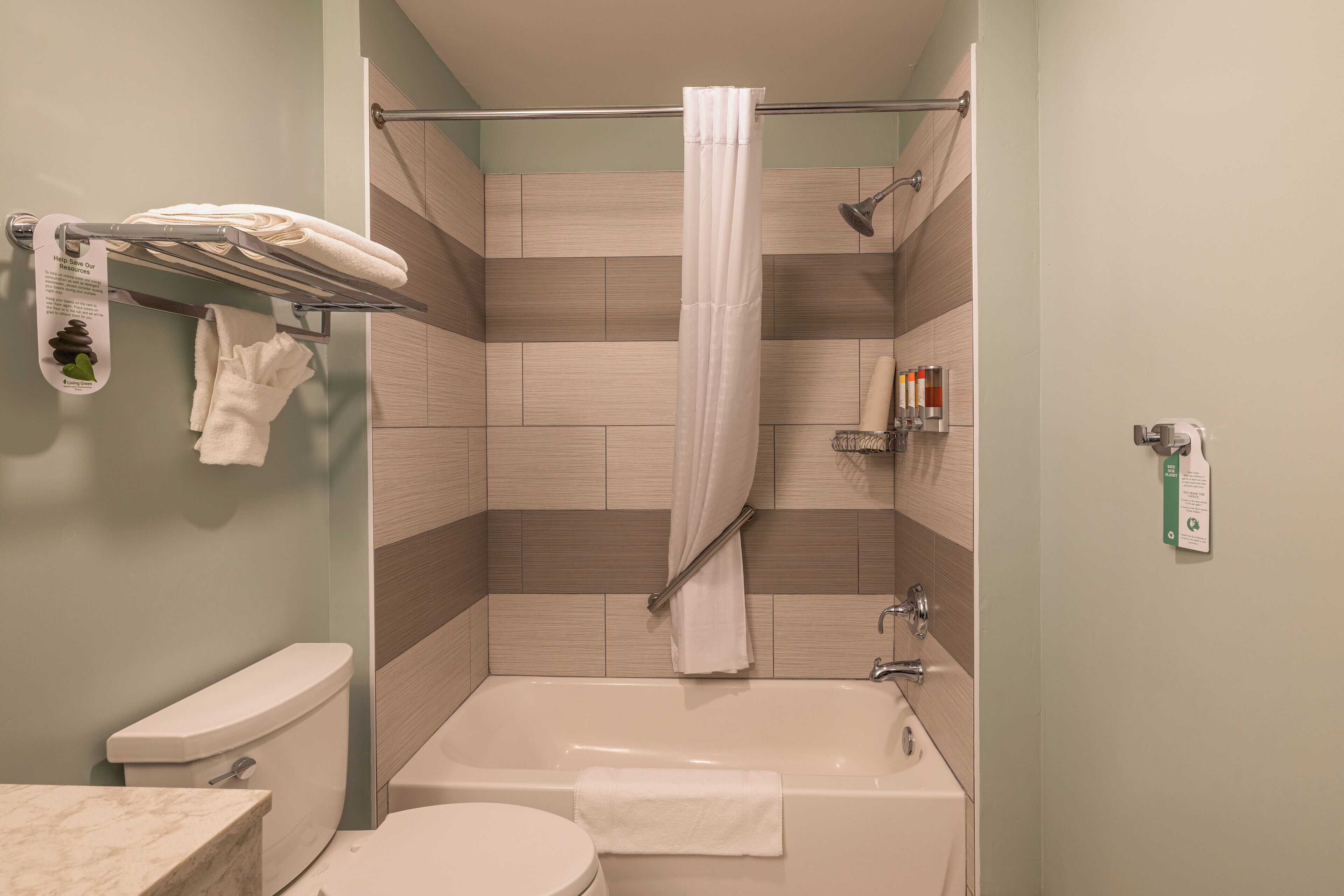 A bathroom with a bathtub, toilet, and towel rack.
