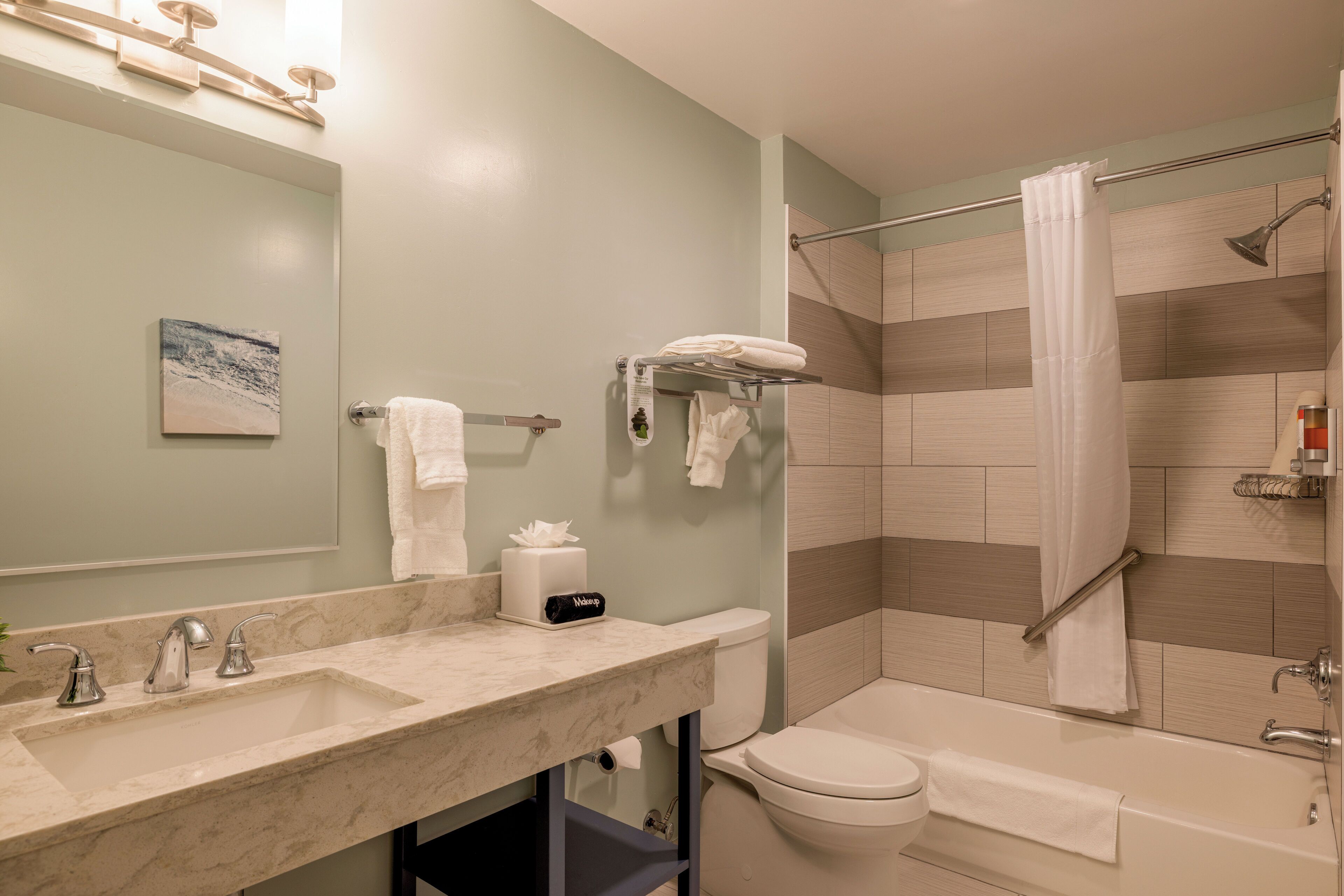 Un baño moderno con lavamanos de mármol, inodoro y bañera.