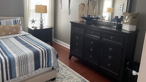 A bedroom with a bed, dresser, and a large mirror. - Wilmington in the middle of it ALL (Wilmington)