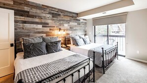 A bedroom with two beds, a wooden wall, a balcony, and a window. - Shadow Ridge 401 | Walk to Lifts | Mtn & Ski Views | Kitchen | Fireplace | Updated | Pool & Hot Tub (Park City)