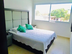 Relax in this serene bedroom with a comfortable bed and a view of the surrounding greenery.