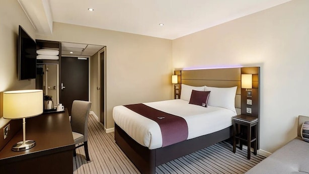 A hotel room with a bed, bedside tables, a desk, and a chair. - Premier Inn Lymington (Lymington)