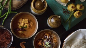 Une variété de plats, notamment un bol de curry, du pain et des légumes frais.