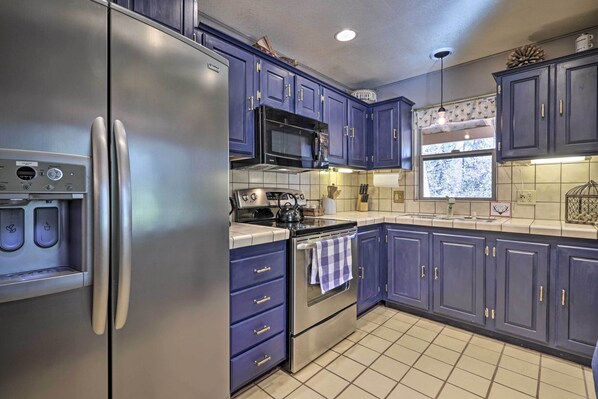 Enjoy cooking in this fully equipped kitchen with a refrigerator, oven, and ample storage.