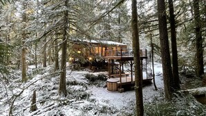A cabin in a snowy forest with a deck and outdoor seating area. - Mt Baker Cabin w/ Cedar Hot Tub & Panoramic Forest Views (Deming)