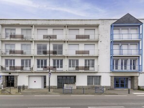 A multi-story building with a flat facade, balconies, and a distinct blue section on the right. - Le Grand Large by Interhome (Quiberon)