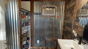 Ein Badezimmer mit Dusche, Toilette, Waschbecken und Handtuchhalter.