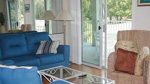 A living room with a blue sofa, a wicker armchair, and a glass coffee table. - 805 2 Bedroom Villa by RedAwning (Calabash)