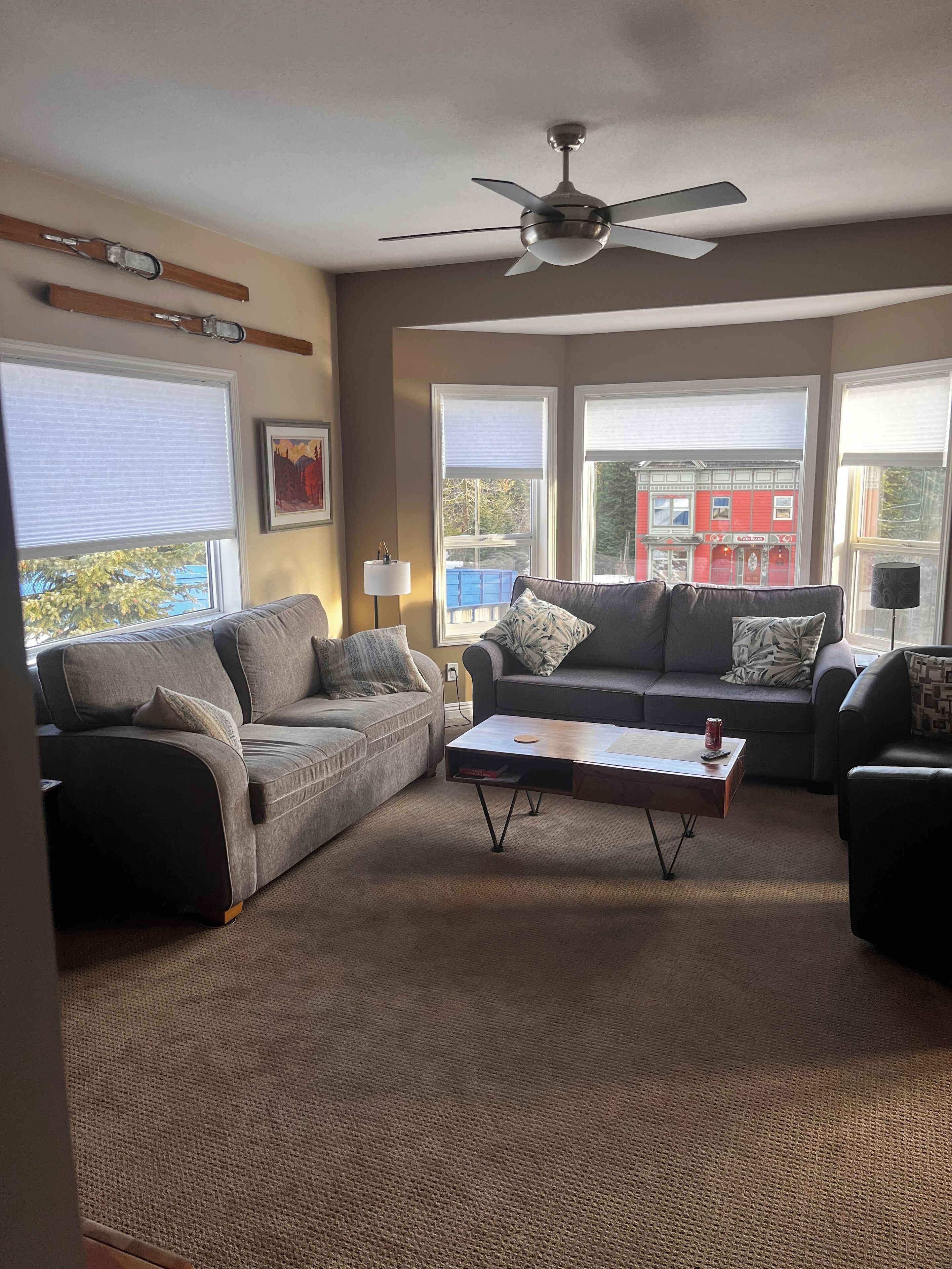 Ein Wohnzimmer mit zwei Sofas, einem Couchtisch und einem Deckenventilator.