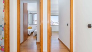 A hallway leading to a bedroom with a bed and a window, wooden flooring, and a view of the city. - Casa de 4 habitaciones, 2 baños, piscina privada, amarre, wifi (Empuriabrava)