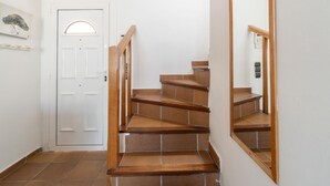 A staircase with wooden steps leading to a white door with a small window. - Casa de 4 habitaciones, 2 baños, piscina privada, amarre, wifi (Empuriabrava)