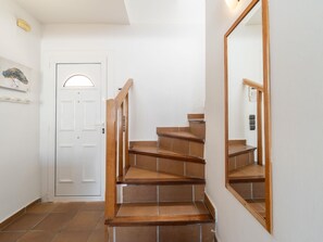 Eine Treppe mit HolzhĂ€uschen fĂŒhrt zu einer weiĂen TĂŒr mit kleinem Fenster.