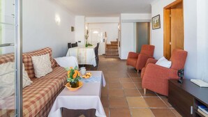 A living room with a sofa, a dining table, and two armchairs. - Casa de 4 habitaciones, 2 baños, piscina privada, amarre, wifi (Empuriabrava)