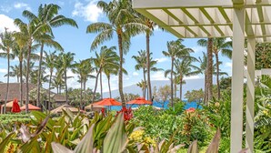 A resort with palm trees, a pool, and a covered area.