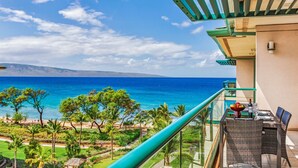 Uma varanda com vista para o oceano e área de refeições com mobiliário de exterior.