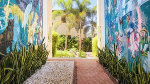 Un sendero conduce a un edificio con murales coloridos en las paredes.