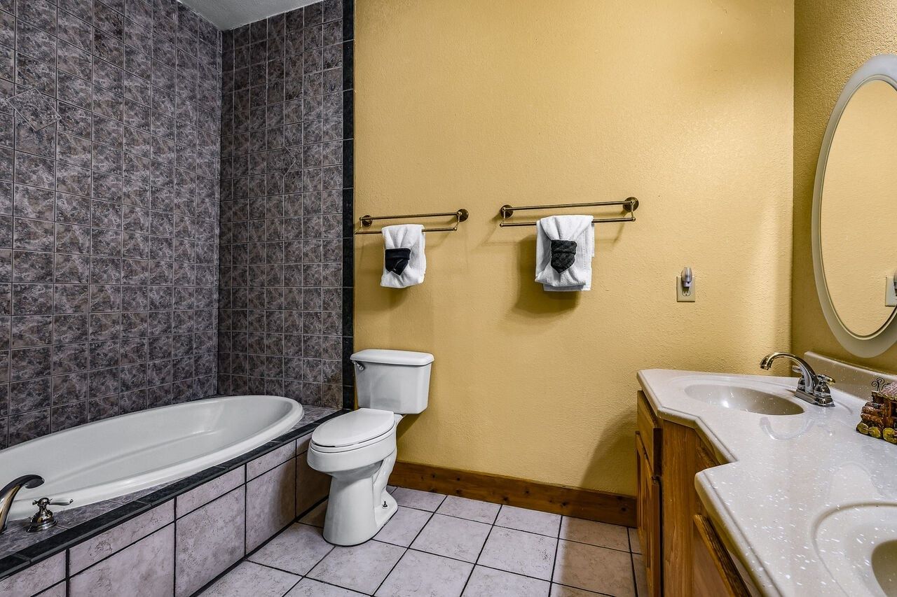 A bathroom with a bathtub, toilet, and vanity with a sink.