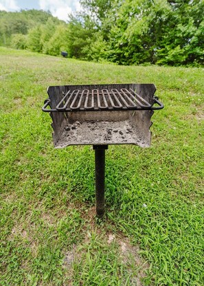 A portable grill on a grassy field.