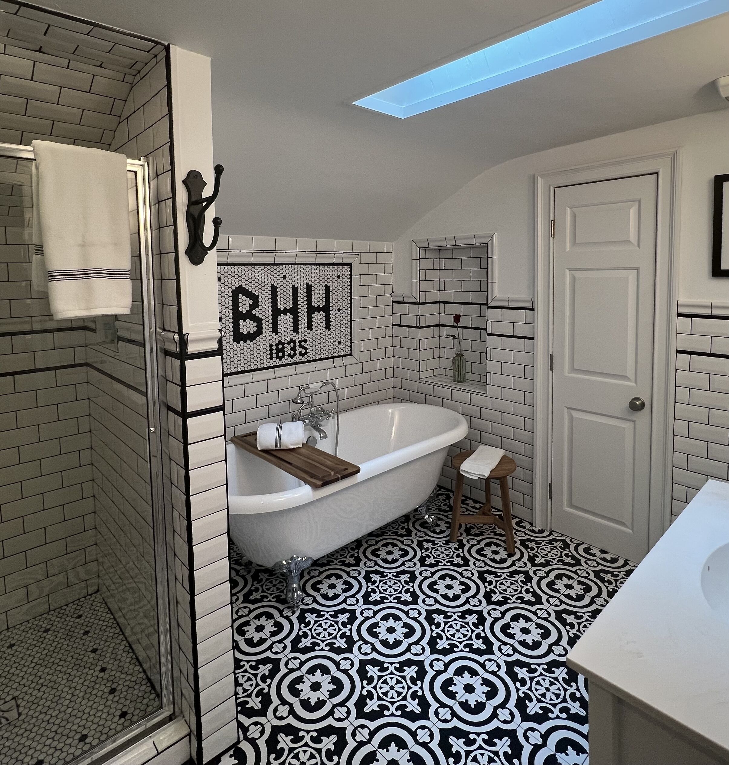 A bathroom with a freestanding bathtub, a shower, and a mirror.