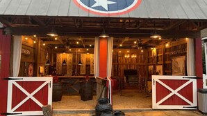 A rustic barn-style building with a large emblem on the roof, wooden interiors, and a vintage aesthetic. - Historic Boyd Harvey House and Grounds 2 Bedroom Home by RedAwning (Knoxville)